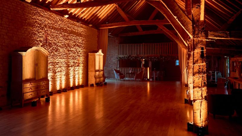 Bury Court Barn in Hampshire with amber colour lighting - Live Wedding Band | wedding band | live music band for wedding | band live wedding | wedding live band price | AKA Party Band