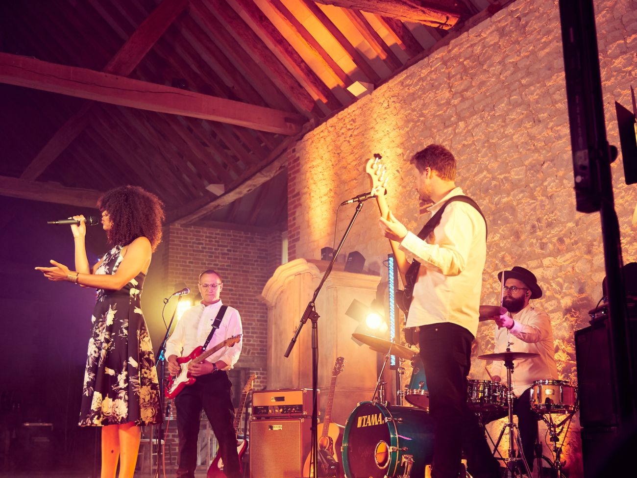 Side on shot of AKA playing at Bury Court Barn against the limestone wall - Live Wedding Band | Surrey wedding entertainment | live band for wedding | Live band for wedding reception | AKA Party Band