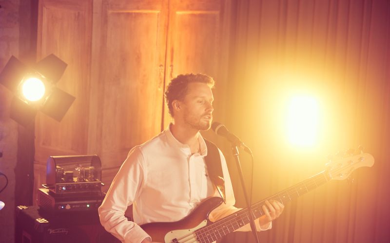 Singer with party lighting at a barn wedding venue in Surrey - Live Wedding Band | Hampshire wedding entertainment | live bands for wedding | Live bands for wedding receptions | AKA Party Band