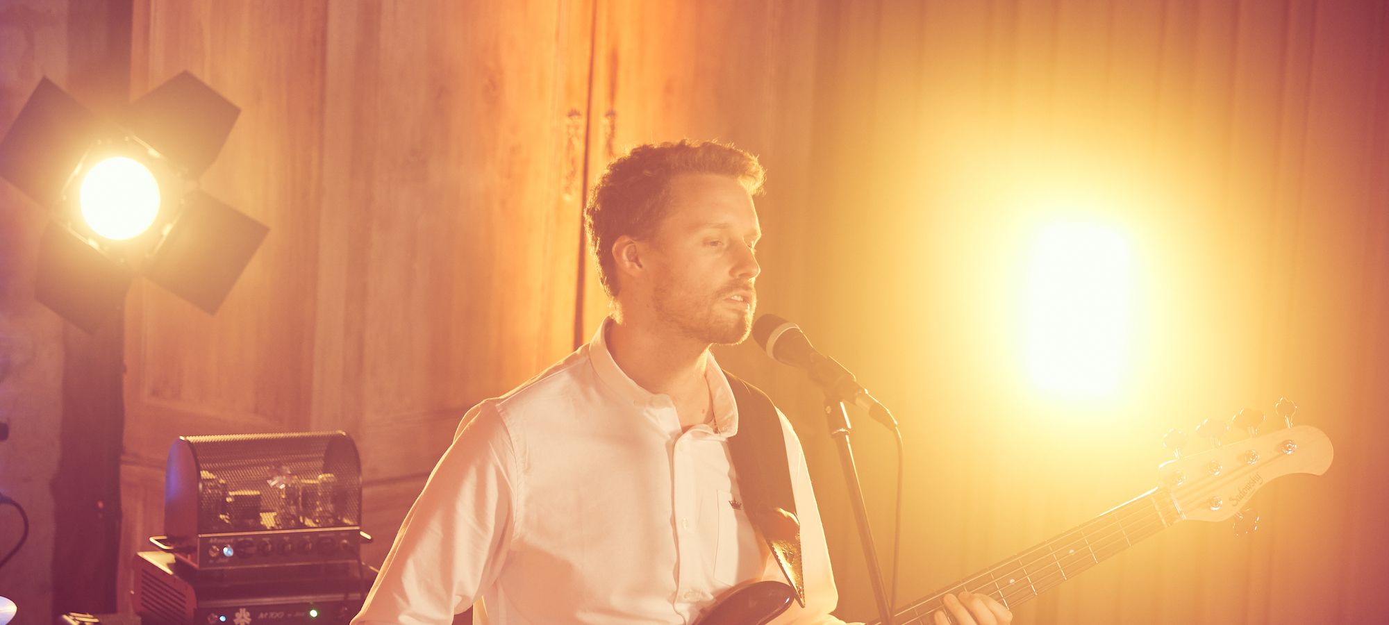 Singer with party lighting at a barn wedding venue in Surrey - Live Wedding Band | Hampshire wedding entertainment | live bands for wedding | Live bands for wedding receptions | AKA Party Band